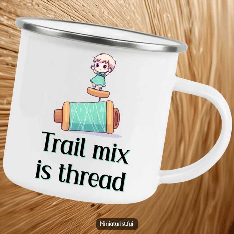 Funny camping mug with a miniaturist character humorously balancing on a giant spool of thread, perfect for outdoor enthusiasts.