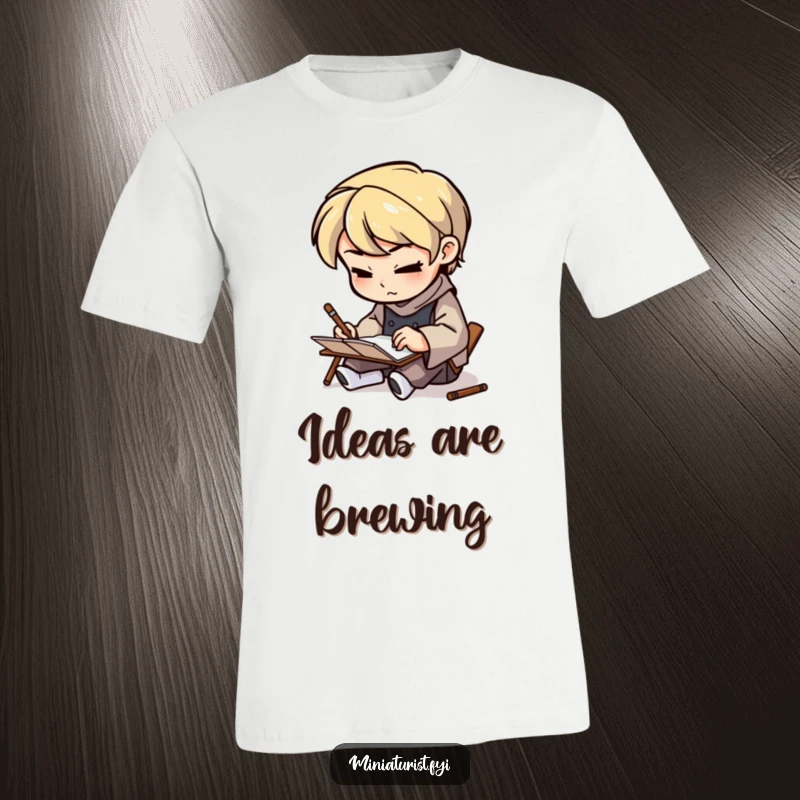 Funny Tiny Artisan T-Shirt featuring a small figure sketching on a tiny notepad with a determined look, celebrating focused creativity humorously.